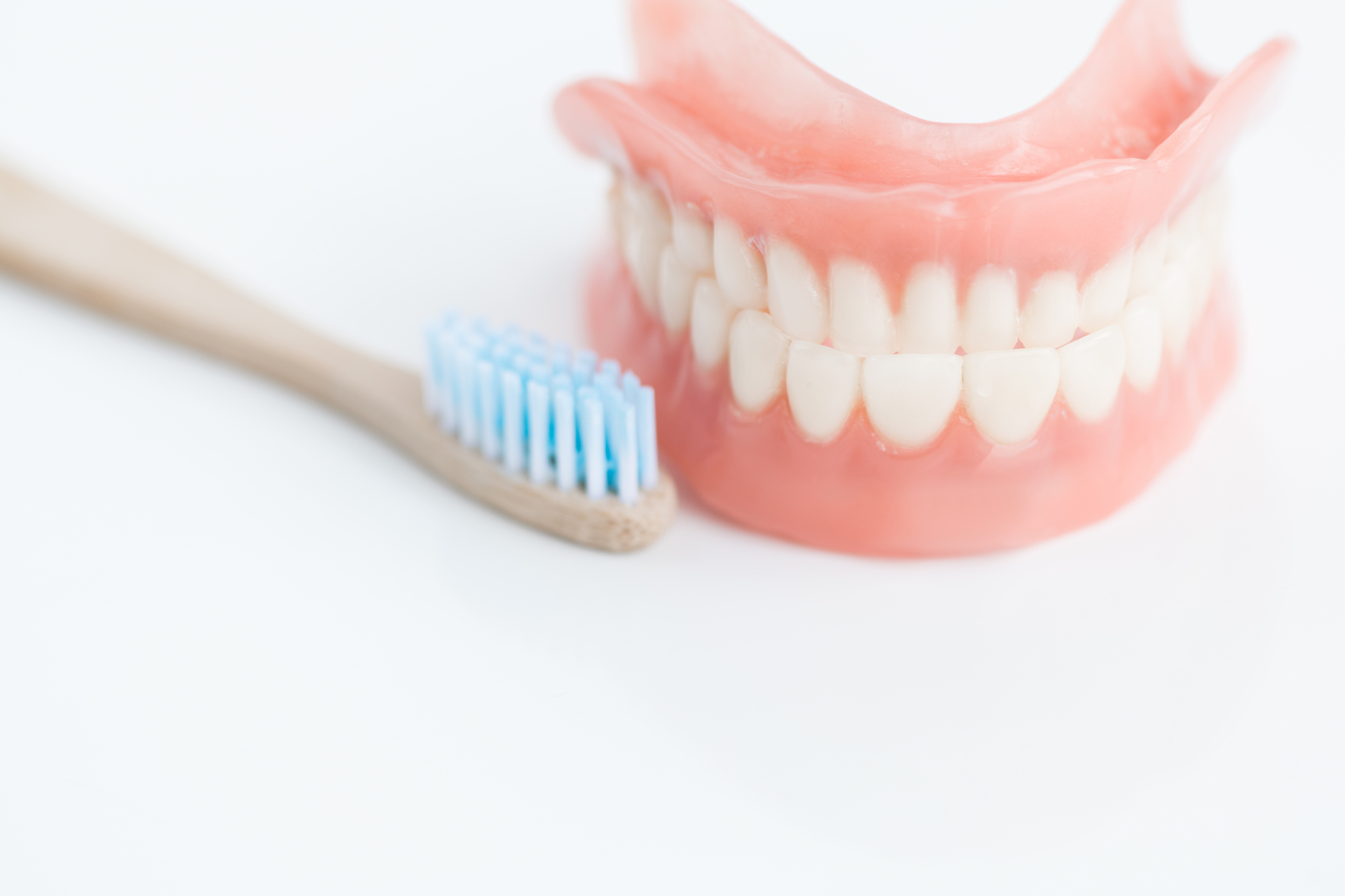 Closeup shot  of toothbrush next to tooth model on white background in dentists office, copy space